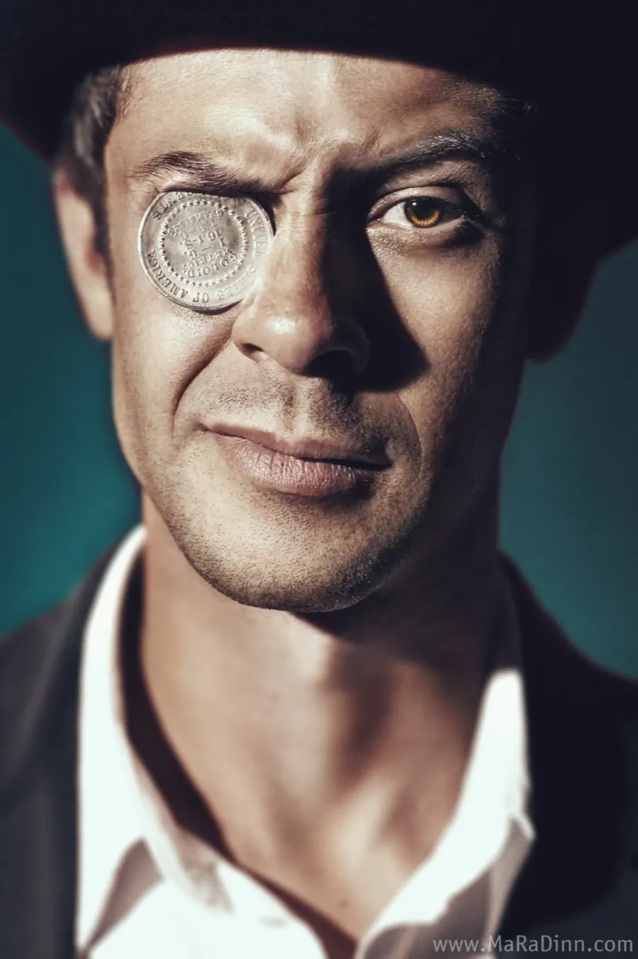 Studio portrait with coin over eye